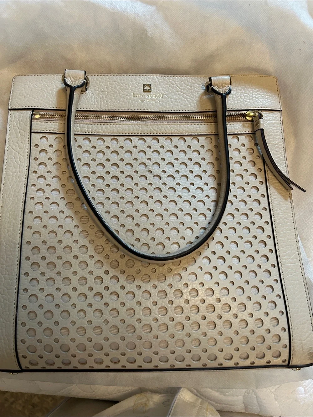 kate spade cream perforated leather tote with black-trim handles